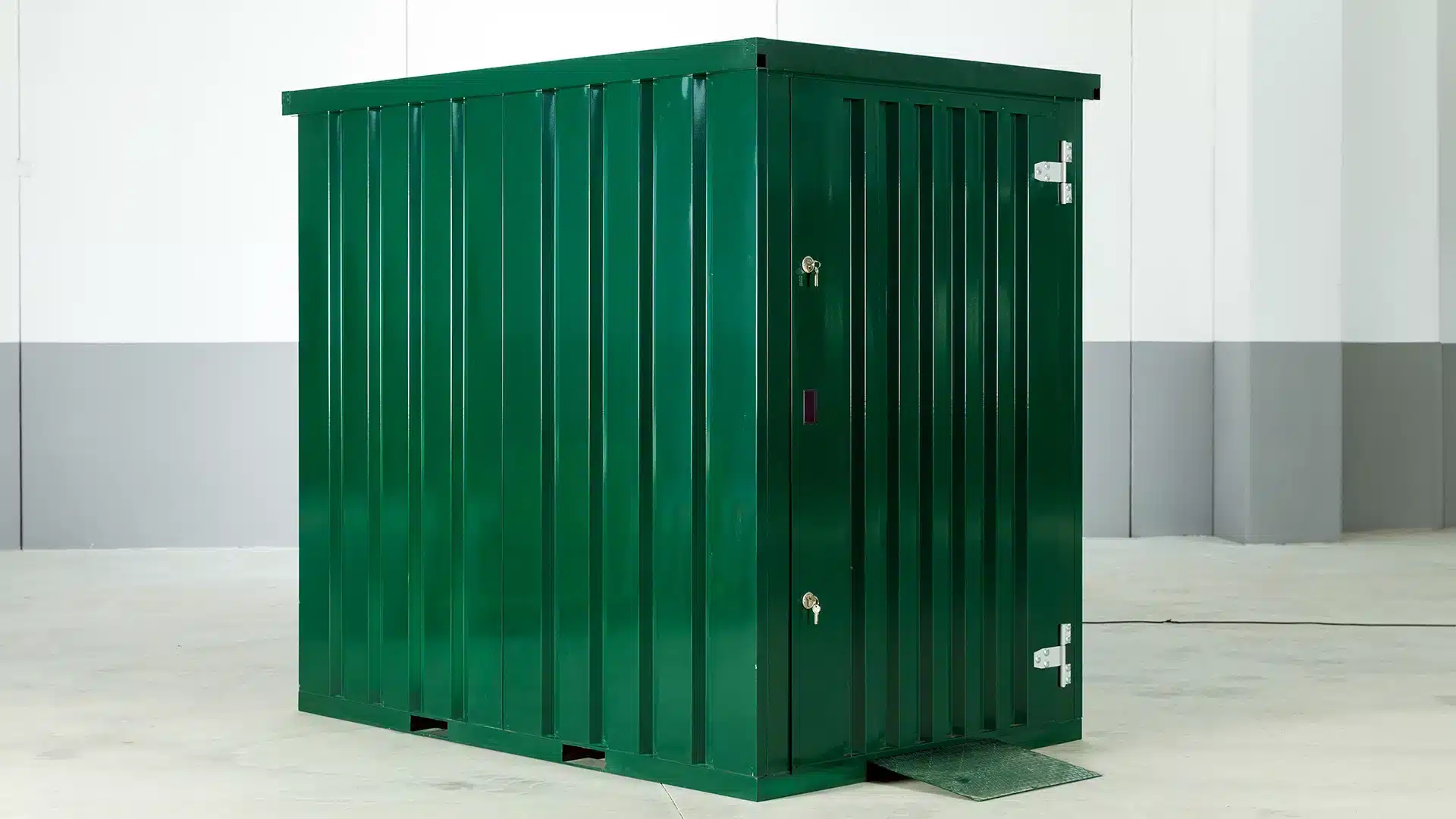 Groene metalen opslagcontainer met dubbele deur, geplaatst in een lichte binnenruimte.