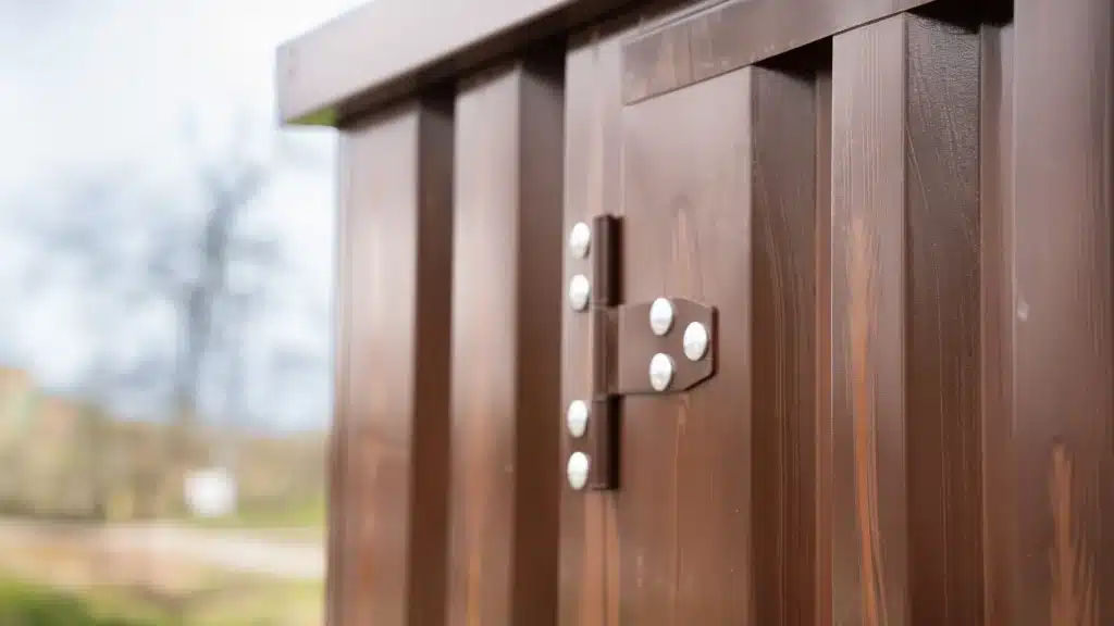Close-up van houtlook poedercoating en scharnier op een stalen demontabele container.