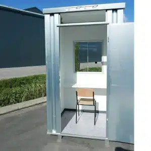 Kassa unit met open deur en open raam geplaats op een parkeerterrein.