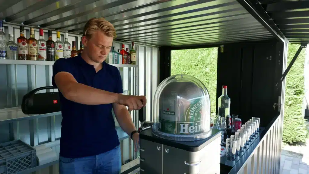 Iemand die een biertje tapt in een barcontainer
