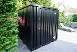 Zwarte opslagcontainer dichte deur in een achtertuin