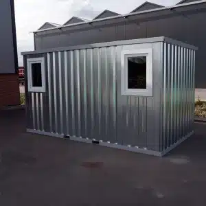 Foto van de container met ramen op een parkeer terrein waar de ramen gemonteerd zijn.