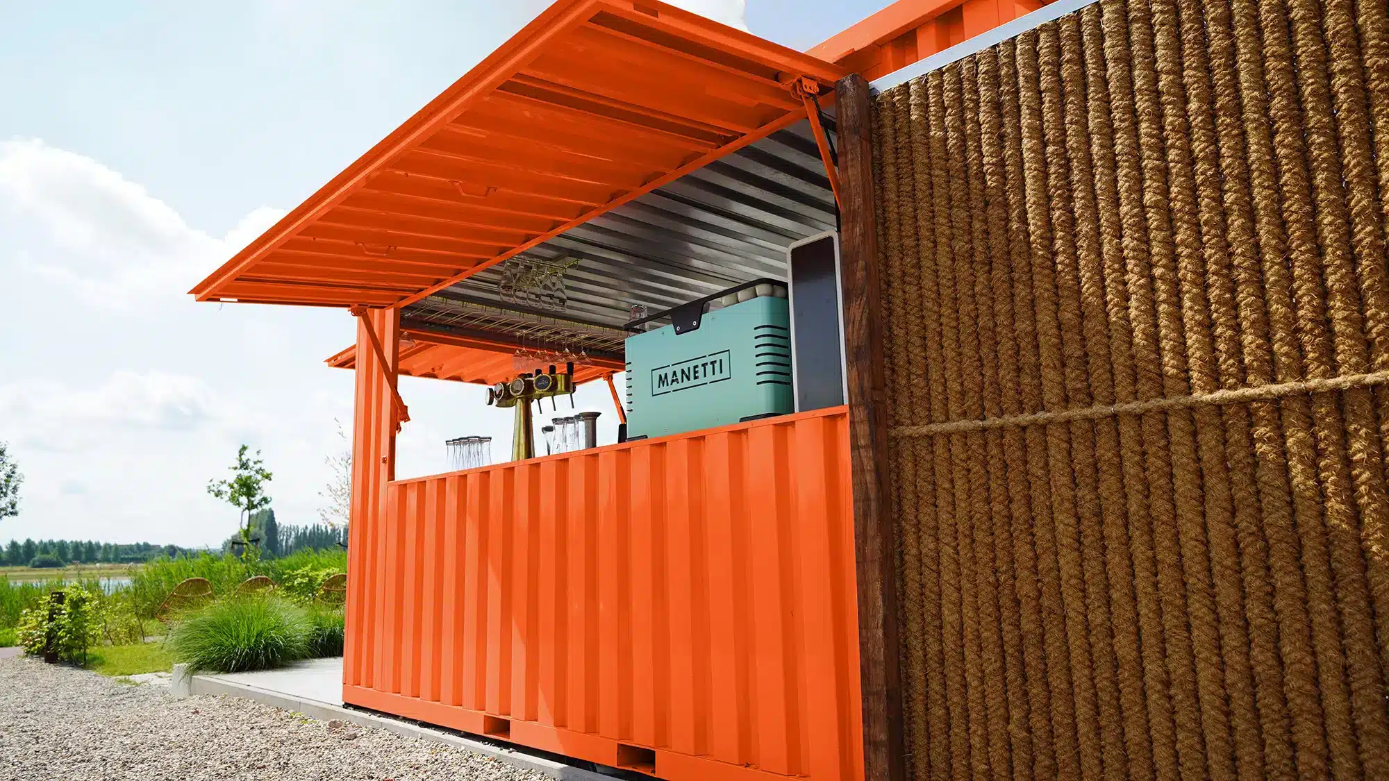 Oranje barcontainer op een terras met twee open kleppen