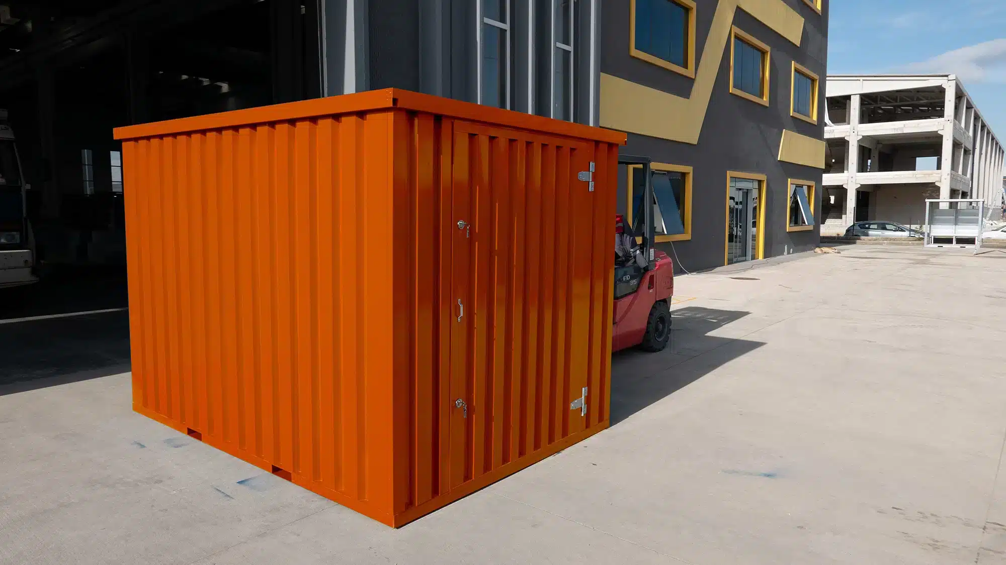 Oranje container met een enkele deur naast een heftruck
