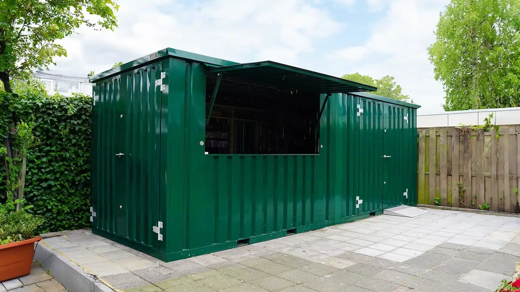 Groene opslagcontainer in de tuin. 1,5x2,2 in de kleur RAL 6000 met een enkele deur aan de korte zijde