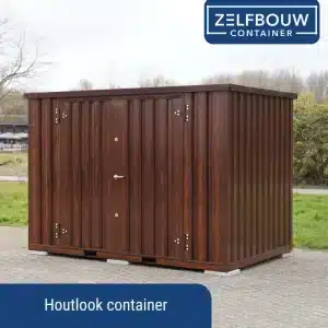 Een metalen container met een houten uitstraling geplaatst op stoeptegels. Er is bestrating te zien aan de voorkant. Achter de container is er gras te zien en een struik. Op de achtergrond is een café te zien.